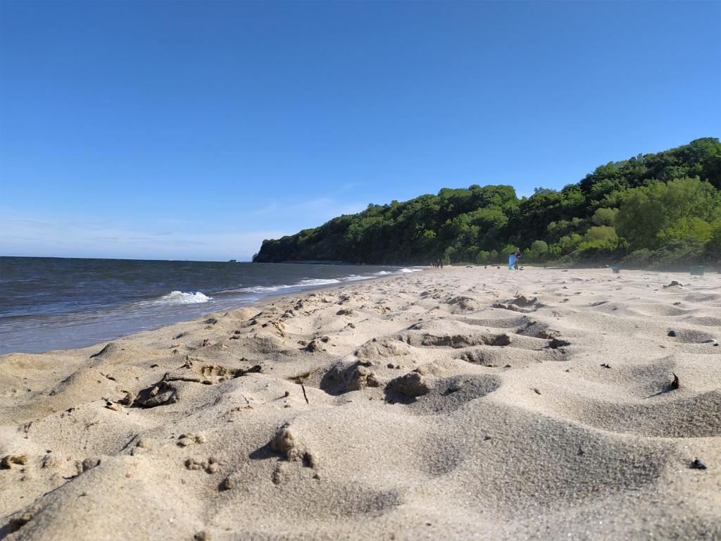 una playa con huellas en la arena y el océano en Apartament przy plaży, en Gdynia