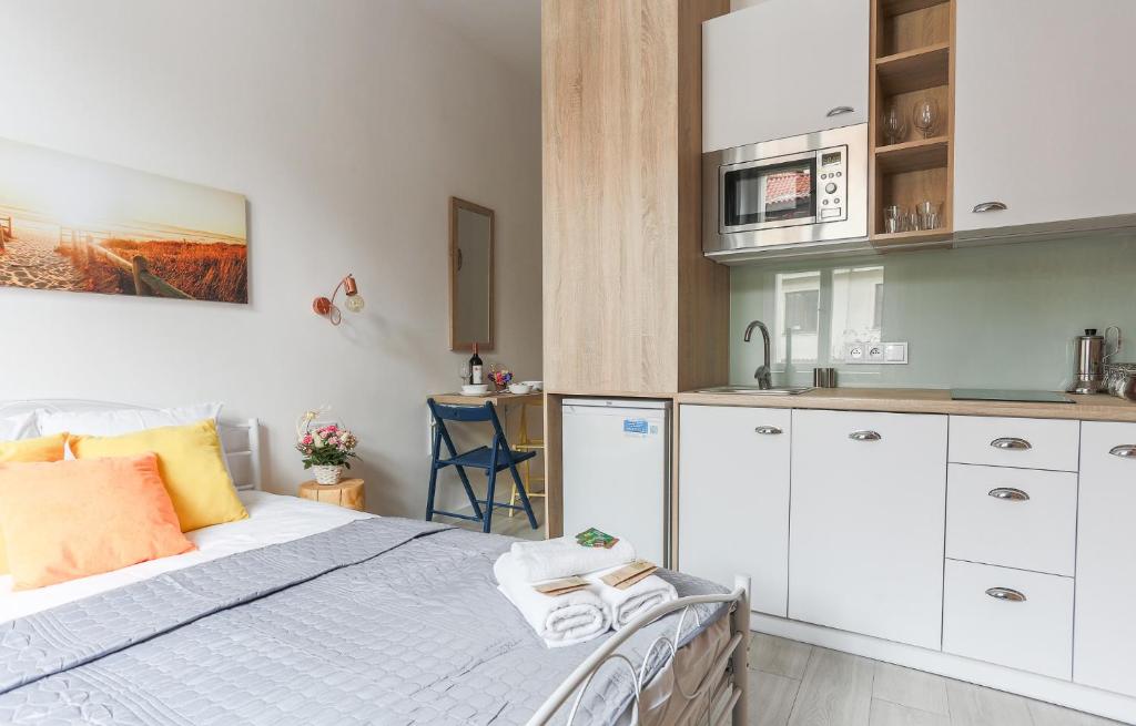 a small bedroom with a bed and a kitchen at Simply Modern Apartment in Toruń