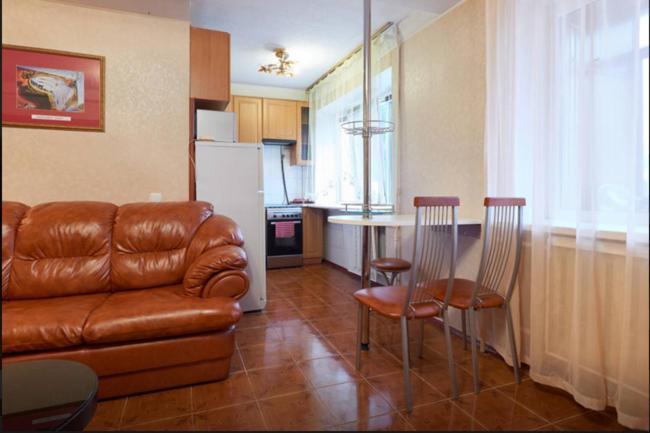 sala de estar con sofá y mesa con sillas en Двушка Печерск, en Kiev
