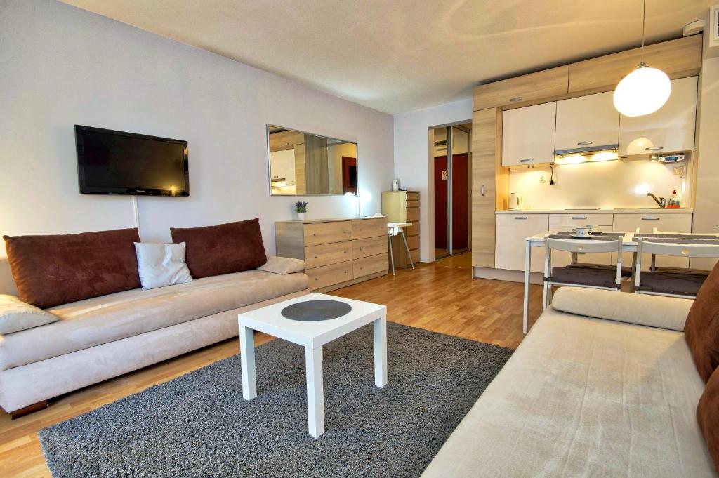 ein Wohnzimmer mit einem Sofa und einem Tisch in der Unterkunft Apartament Park Zdrojowy 2 in Świnoujście