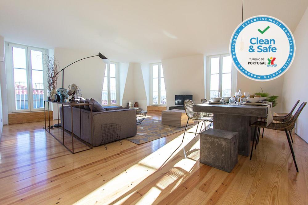 a living room with a wooden floor and a table at Luxury T.M. Penthouse With a View in Lisbon