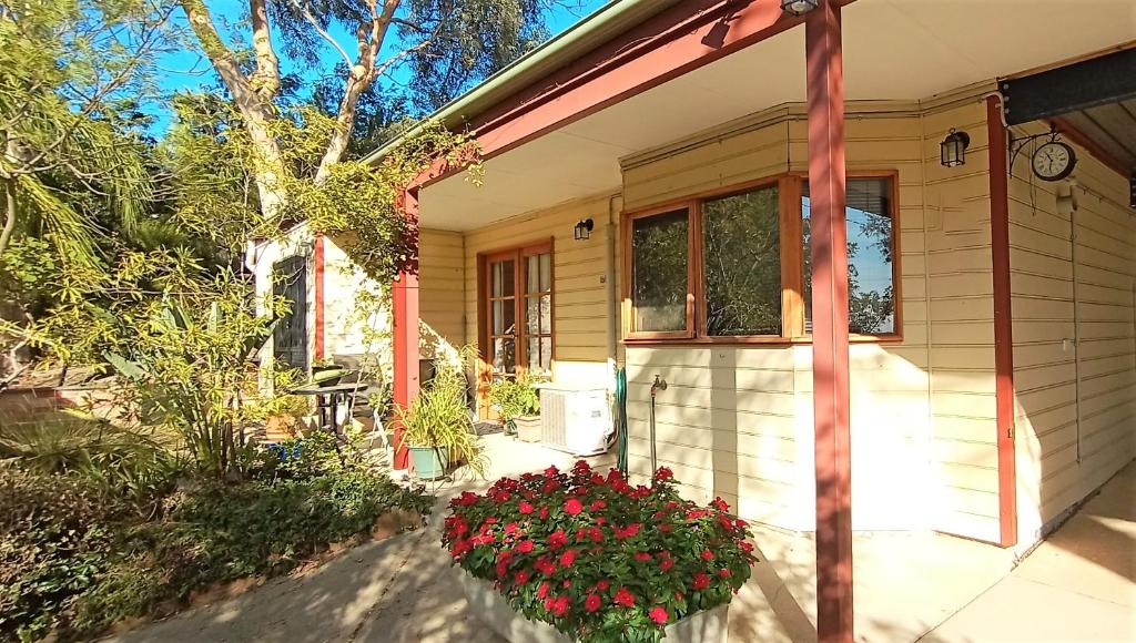 a house with flowers in front of it at Treetops Hideaway Albury in Albury