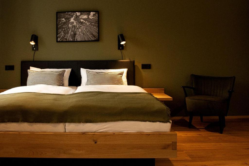 um quarto com uma cama grande e uma cadeira em Holzfellas Home em Wiesau