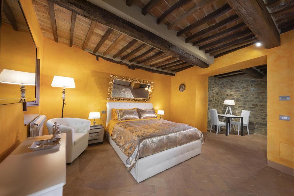 1 dormitorio con 1 cama, mesa y sillas en La Togata Hotellerie de Charme Relais il Terrazzo, en Montalcino