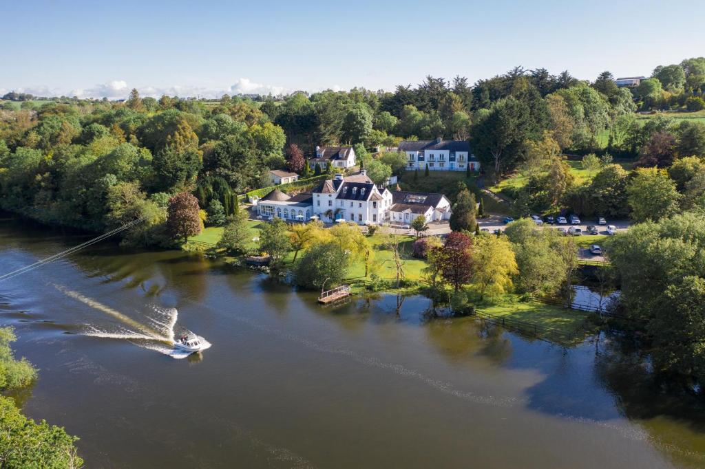 an aerial view of a house on a river with a boat at Innishannon House Hotel in Inishannon