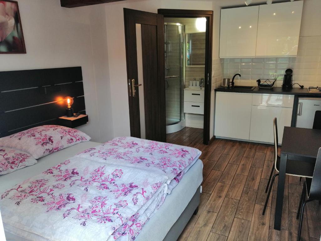 um quarto com uma cama, uma mesa e uma cozinha em Pokoje Zacisze Leśne em Stegna