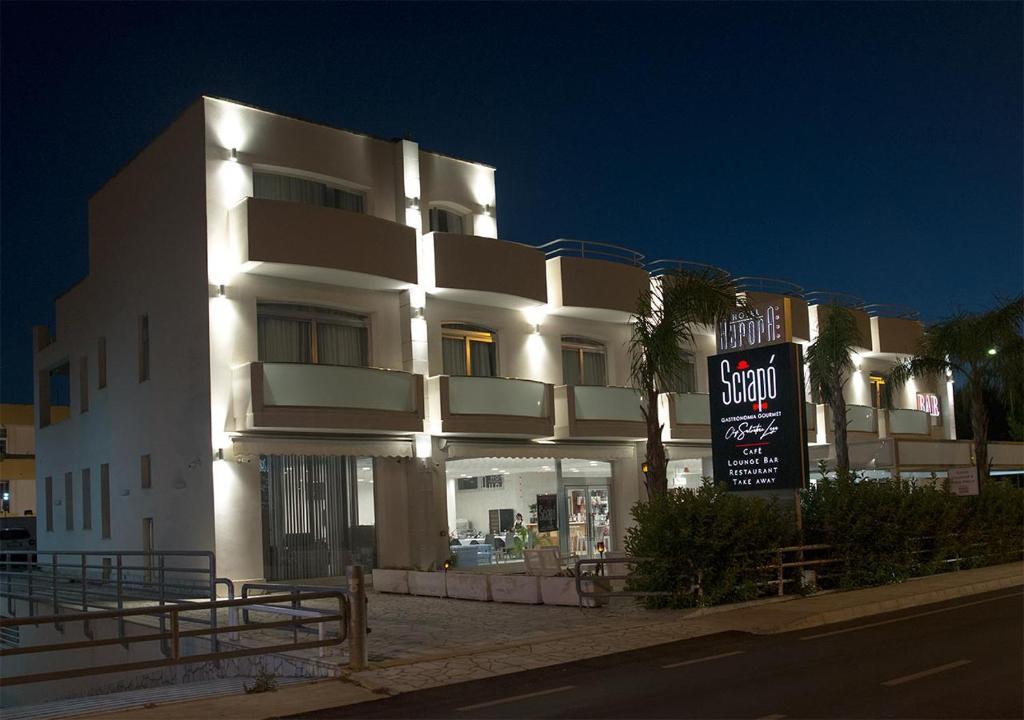 a large white building with a sign in front of it at Hotel Aurora in Porto Cesareo