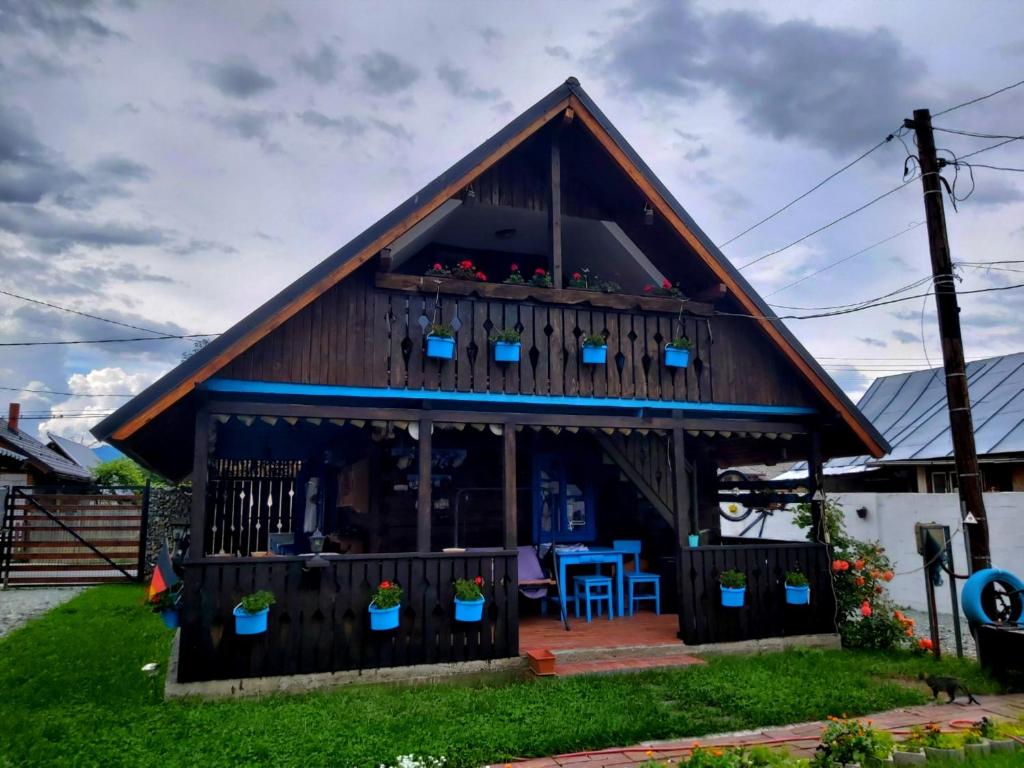 een huis met een gambrel dak en een veranda bij Casa Toth in Vişeu de Sus
