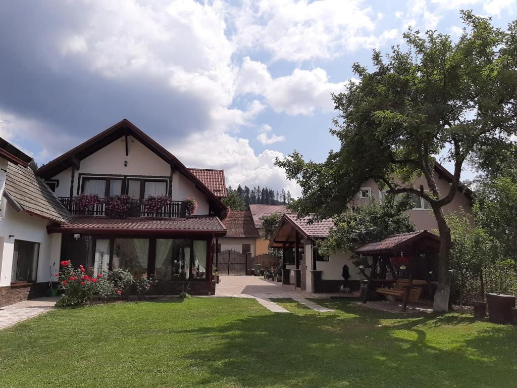 una casa con un árbol y un patio de césped en Vila Nicolai en Cristian