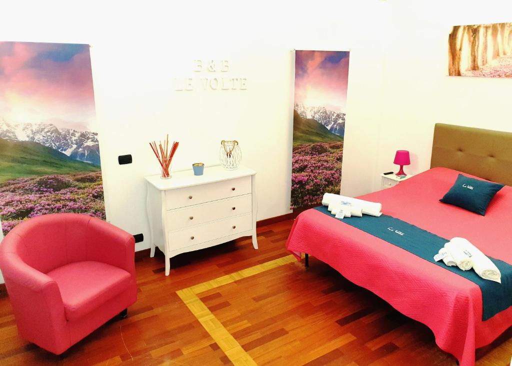 カステッラネータにあるB&B Le Volteのベッドルーム(赤いベッド1台、椅子付)