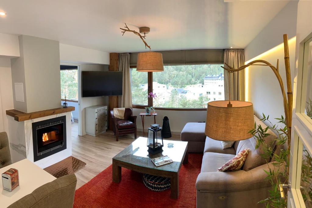 sala de estar con sofá y chimenea en Apartamento con encanto Puerto de Navacerrada, en Cercedilla