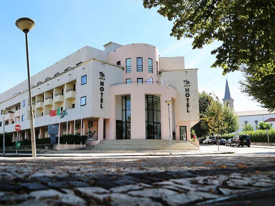 un gran edificio blanco en la esquina de una calle en Hotel das Taipas, en Guimarães