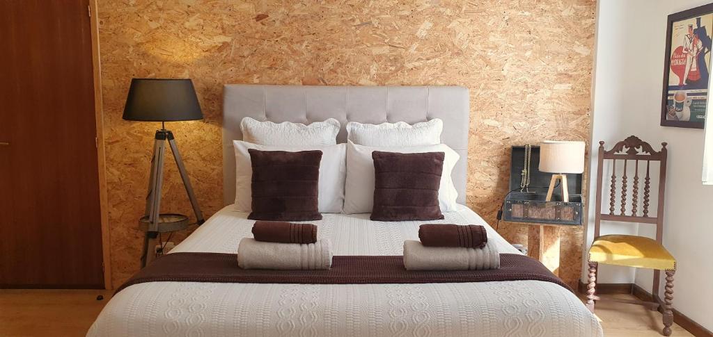 a bedroom with a large white bed with brown pillows at Casa do Criativo ® Bed&Breakfast in Almada