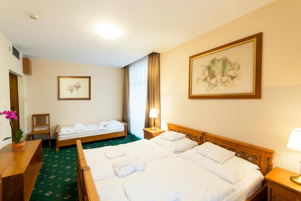 Postel nebo postele na pokoji v ubytování Orchidea Hotel Lipót