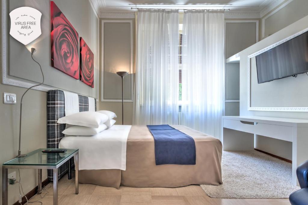 a hotel room with a bed and a tv at Ramé Suites in Bergamo