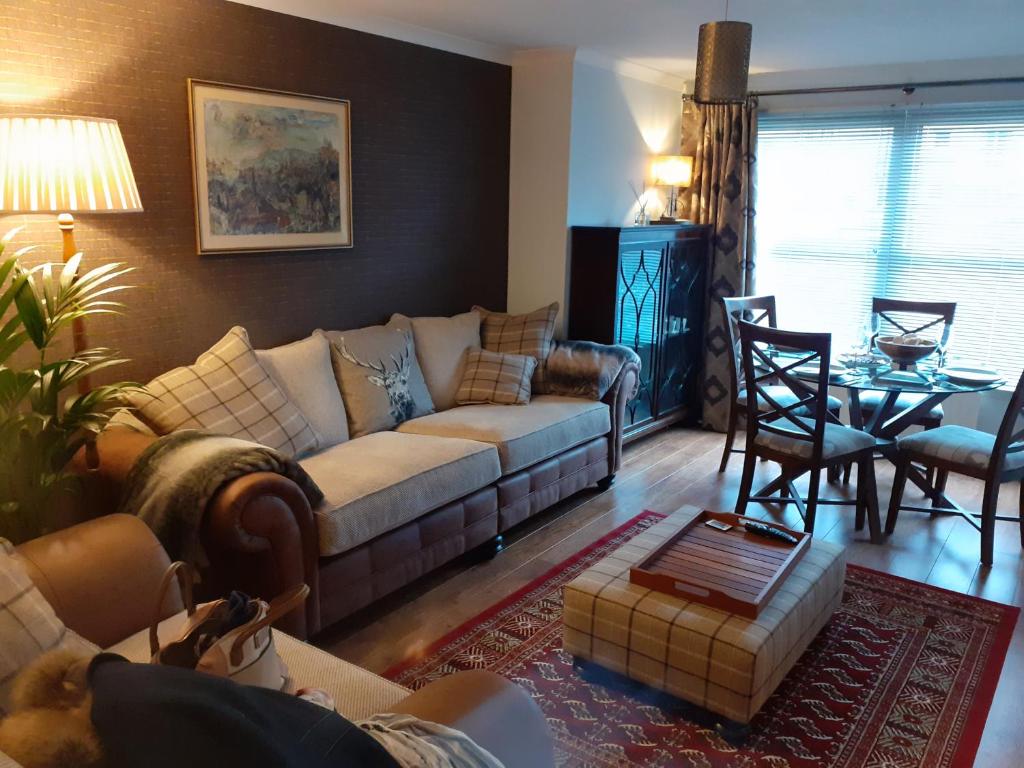 uma sala de estar com um sofá e uma mesa em Bishops Park Apartment em Inverness