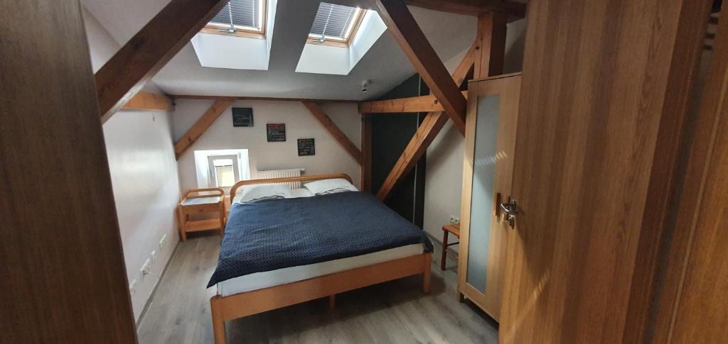 a small bedroom with a bed in a attic at Pentagos Centrum in Poznań