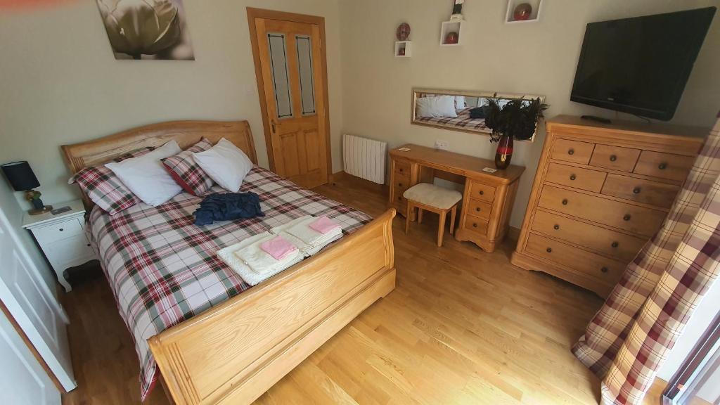 Dormitorio con cama, escritorio y TV en Ardconnel Apartment, en Inverness