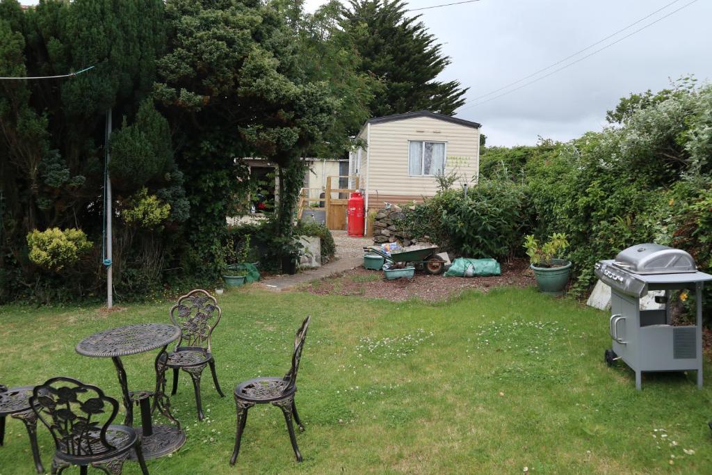 a yard with chairs and a table and a grill at Kimberley Lane Static, Cornwall in Gwennap