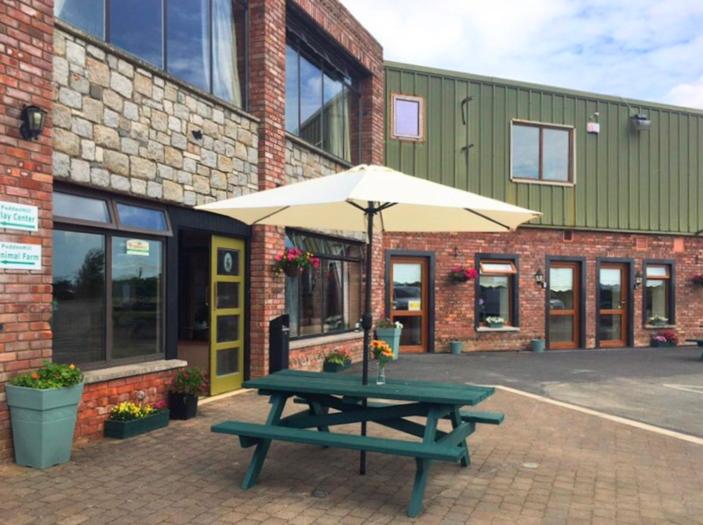 a picnic table with an umbrella in front of a building at Tara View Apartments in Garristown