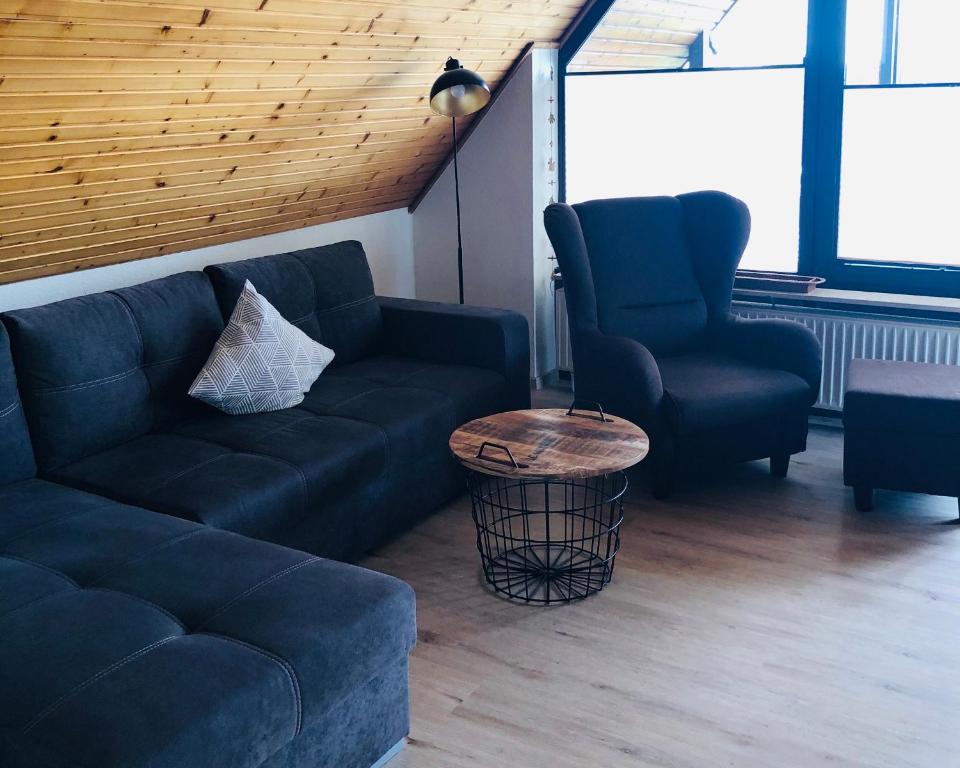 a living room with a couch and two chairs at Ferienwohnung Bolle in Hooksiel