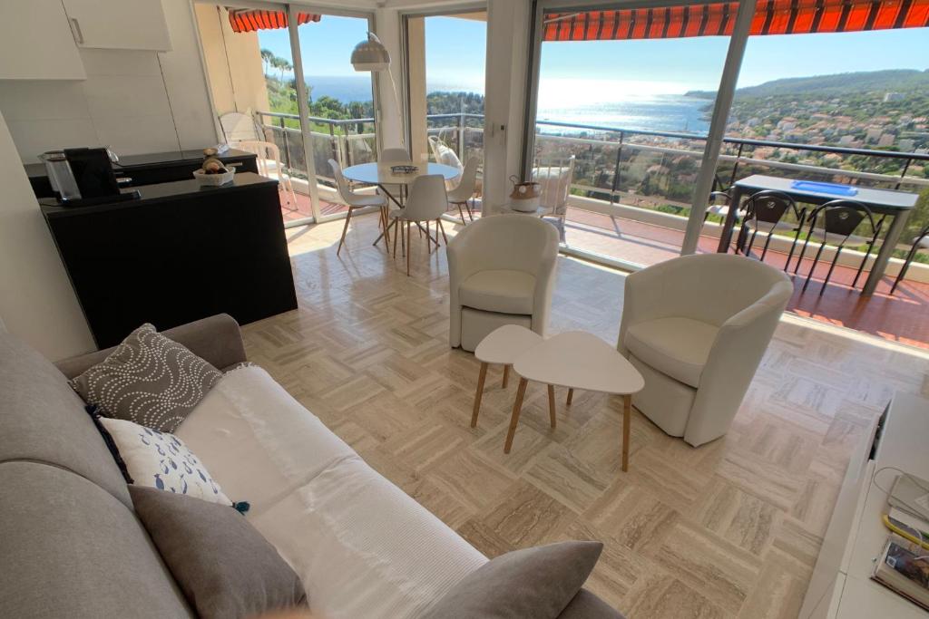 un salon avec un canapé et des chaises et une grande fenêtre dans l'établissement GALETS BLEUS by K6 Conciergerie Prestige, à Cassis