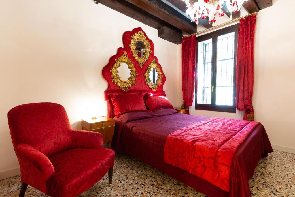 威尼斯的住宿－Granda Sweet Suites，一间卧室配有红色的床和椅子