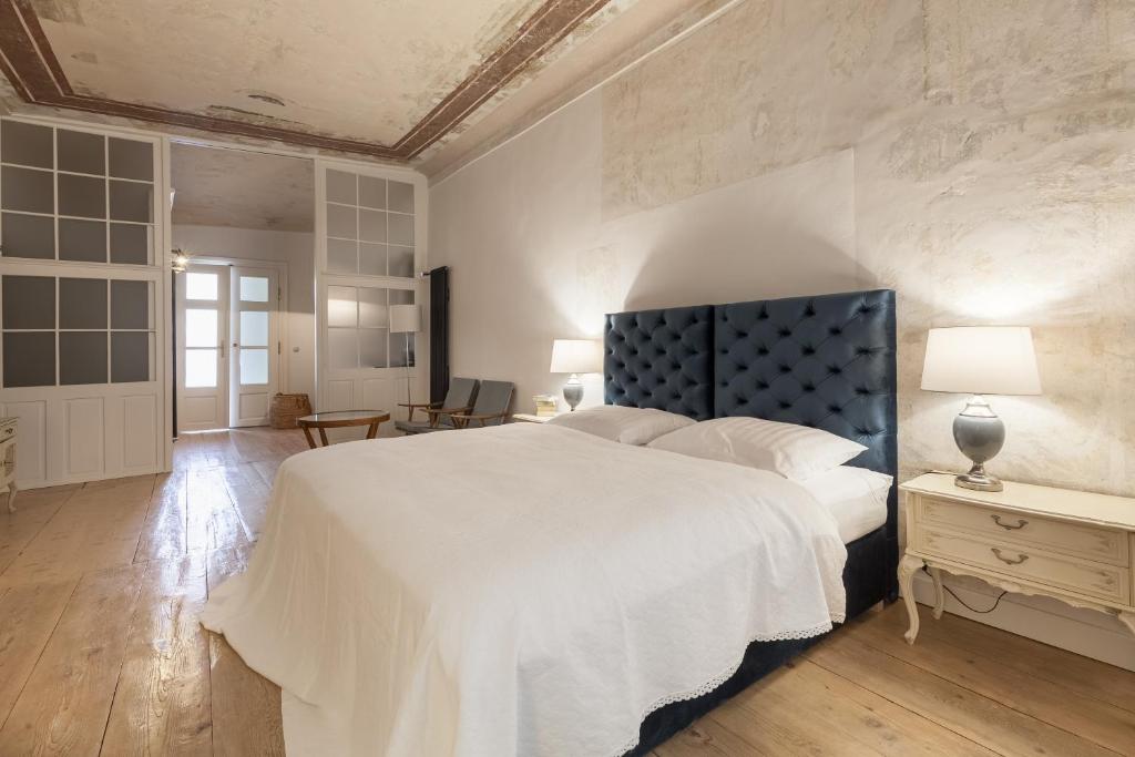 a bedroom with a large white bed with a blue headboard at Apartments 1620yr Trnava in Trnava