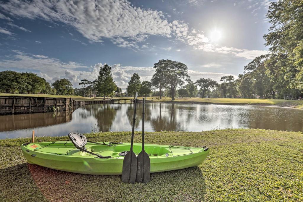 a green boat sitting on the grass next to a river at Lake Charles Home 1 Mi to Public Boat Launch in Lake Charles