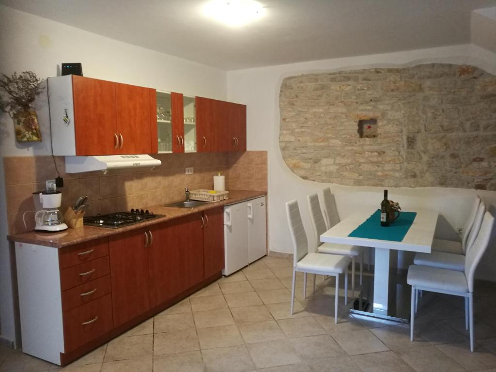 kuchnia ze stołem i stołem oraz kuchnia z kuchenką w obiekcie Villa Piazza grande w Fažanie