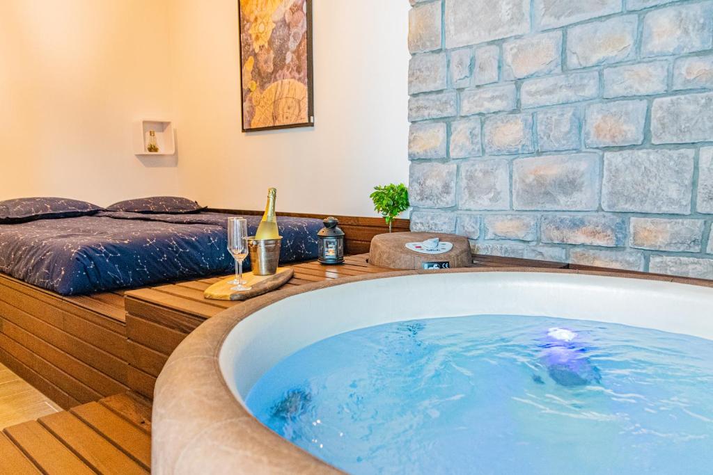 a bath tub in a room with a bed at Jacuzzi - Flexible SelfCheckIns 20 - Zagreb - Luxury - Garage - Smart - Brand New - Apartments Repinc in Zagreb