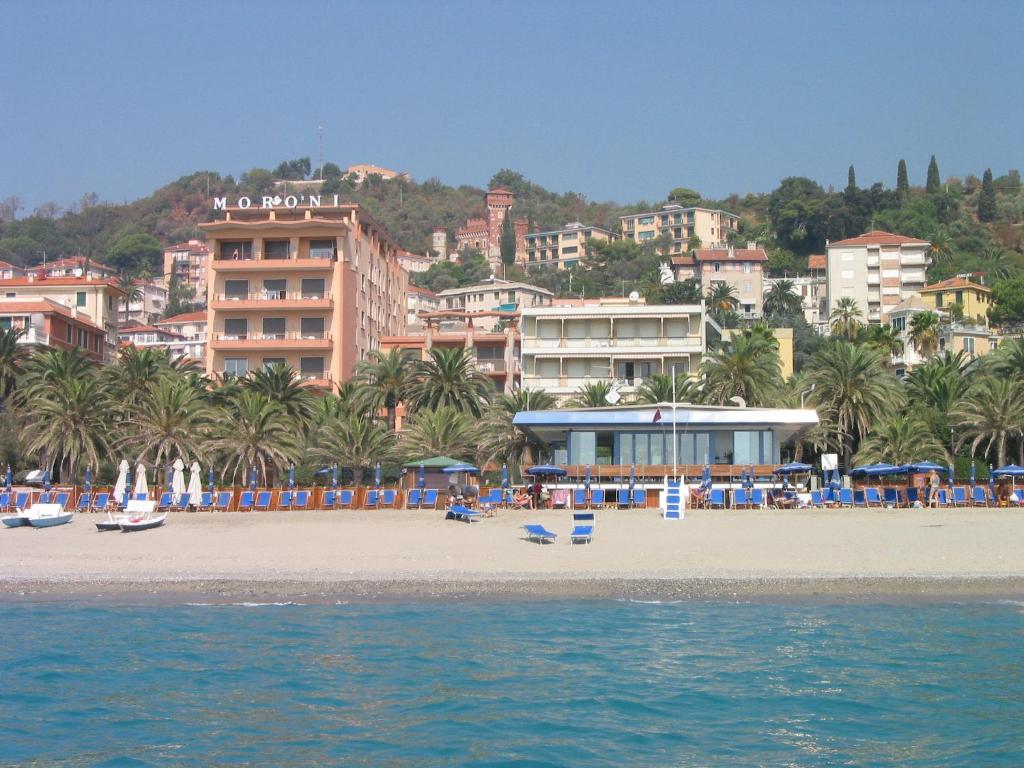 a view of a beach with buildings and palm trees at Grand Hotel Moroni in Finale Ligure
