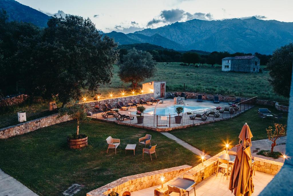 a resort with a swimming pool and mountains in the background at B&B A Chjusellina in Corte