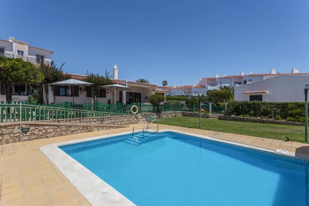 una gran piscina azul en un patio con casas en Villa Morena, en Albufeira