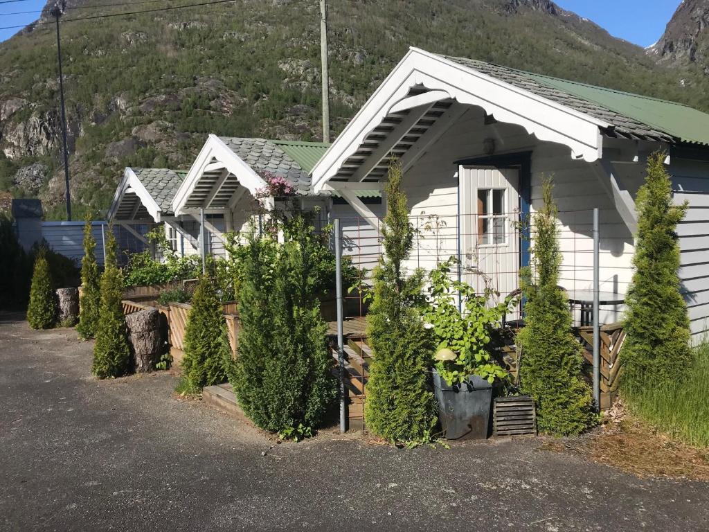 a white house with plants in front of it at Eidfjord Hytter in Eidfjord