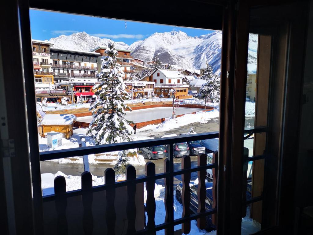 a view of a snowy mountain from a window at Hôtel Le Blainon in Auron