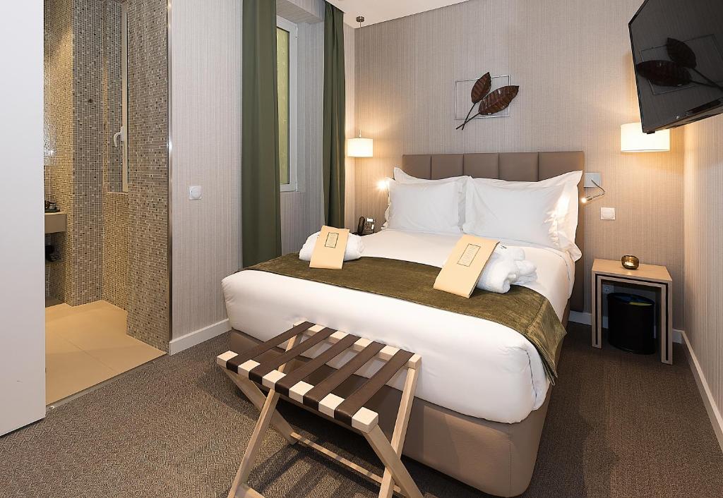 een hotelkamer met een groot bed en een bank bij The Leaf Boutique Hotel Lisbon - Adults Only in Lissabon