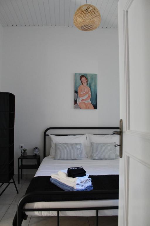 a bedroom with a bed and a painting on the wall at Cycladic Villa in Amorgos Island (Maison Shiro) in Arkesíni