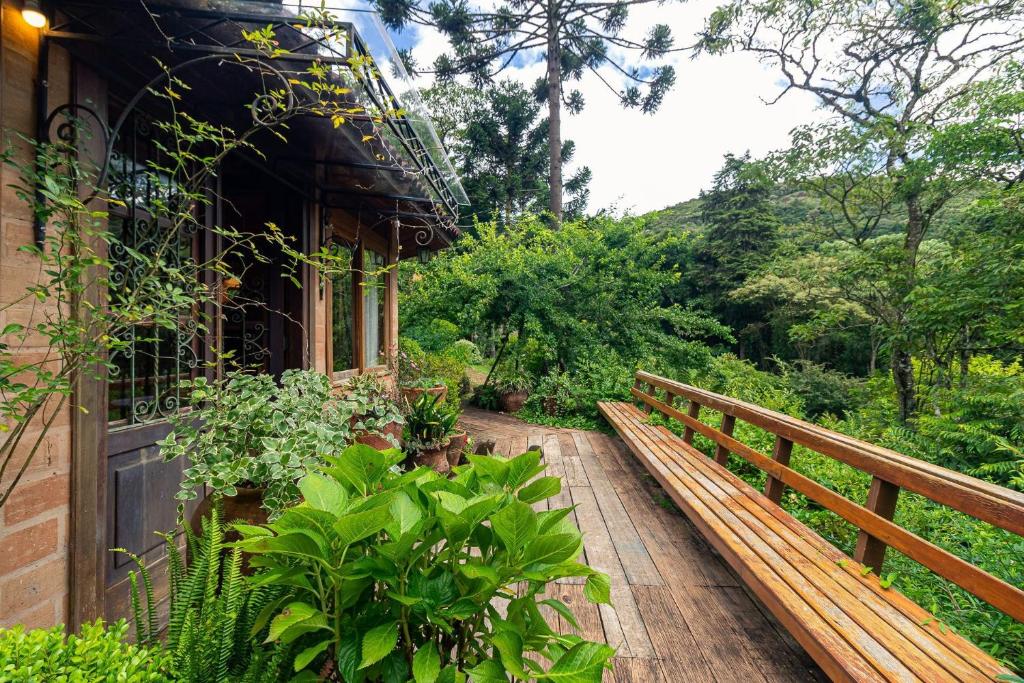 a wooden walkway leading to a house with plants at Vale do Lajeado - Mountain chalets in Campos do Jordão