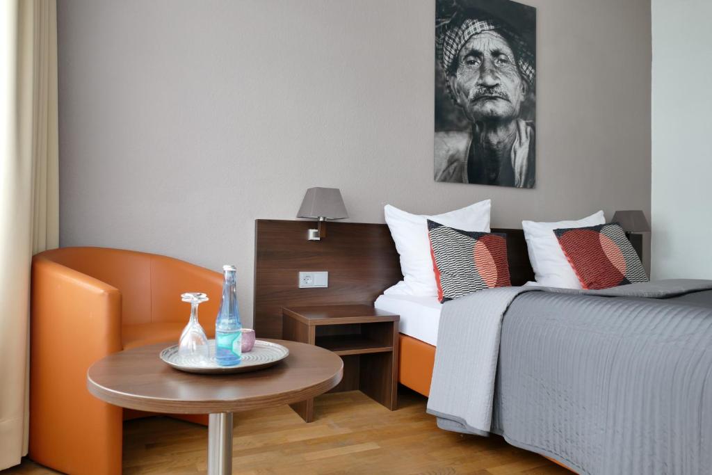 um quarto de hotel com uma cama e uma mesa com uma mesa em DAS Steeps Ihr Brauhaus und Hotel em Colônia