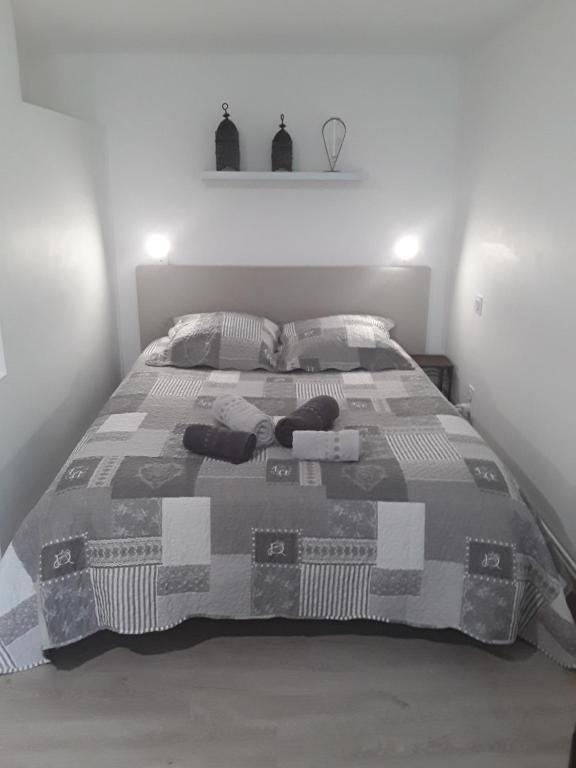 - une chambre dotée d'un lit avec une couverture et des oreillers dans l'établissement Gîte les Oliviers les HERBIERS, aux Herbiers