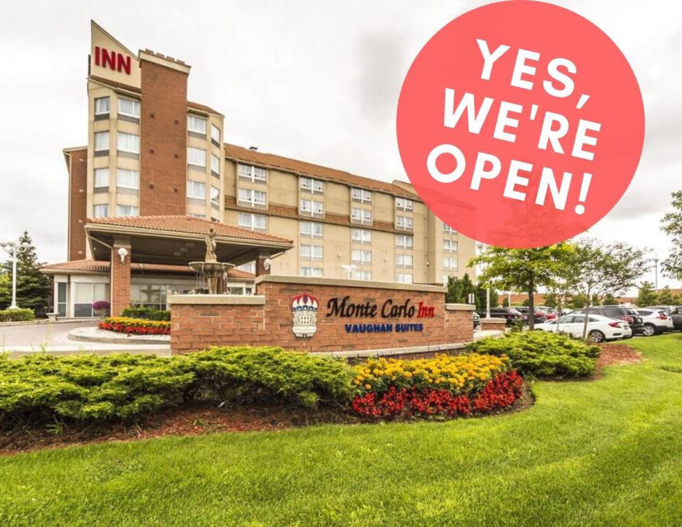 a sign that reads yes were open in front of a hotel at Monte Carlo Inn Vaughan Suites in Vaughan
