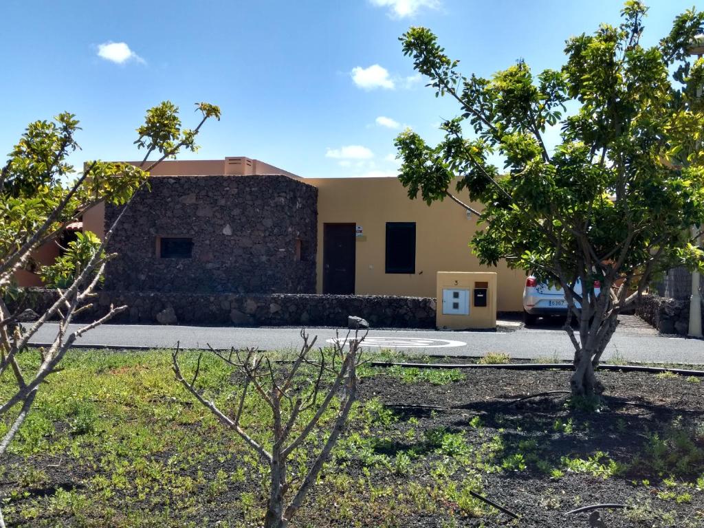 un edificio con árboles delante de él en La Casita, en La Oliva
