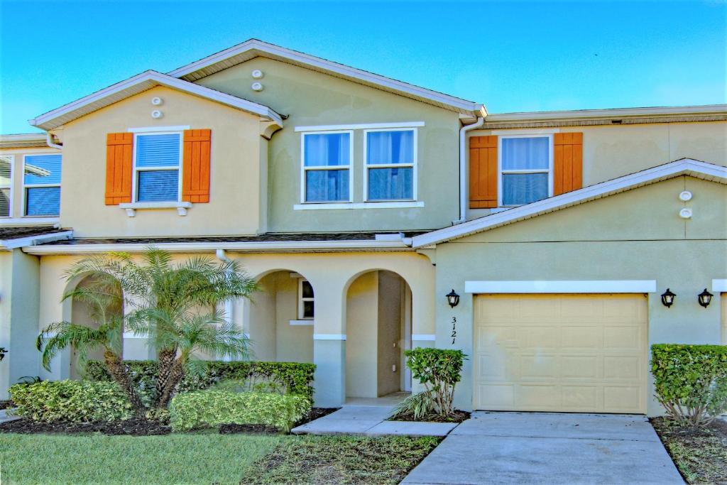 a house with a garage in front of it at 4 Bedroom SunHaven Townhouse with Pool Near Disney in Kissimmee