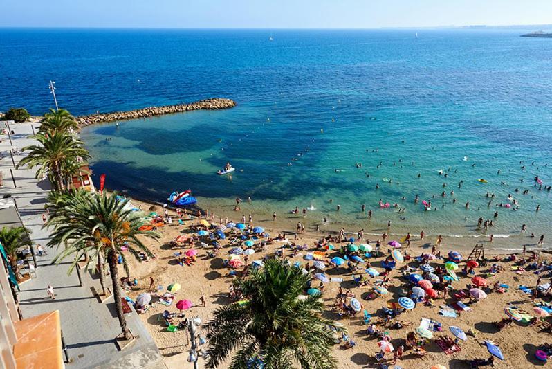 a beach with a lot of people in the water at La Loma de Torrevieja in Torrevieja
