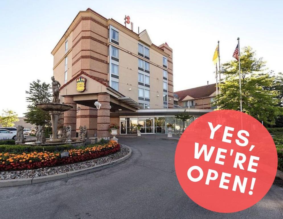 a sign that says yes we are open in front of a hotel at Monte Carlo Inn Airport Suites in Mississauga