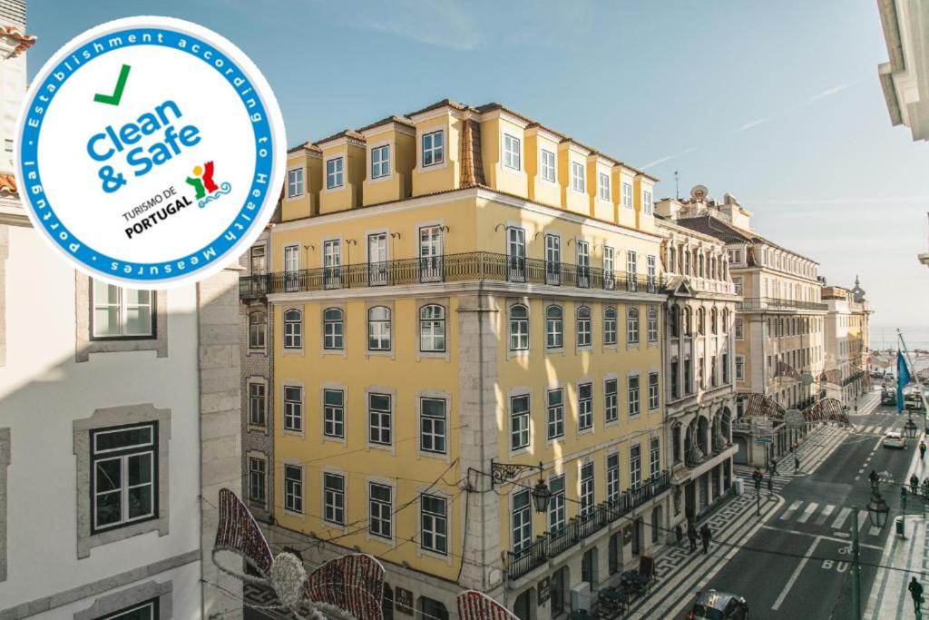 ein großes gelbes Gebäude mit einem Schild, auf dem "okay" steht und beschlagnahmt wird. in der Unterkunft Grand Ouro Deluxe Apartment Downtown Baixa in Lissabon