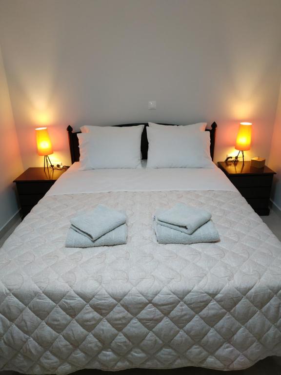 un grande letto bianco con due cuscini sopra di Arxontia 2 a Kalamáta