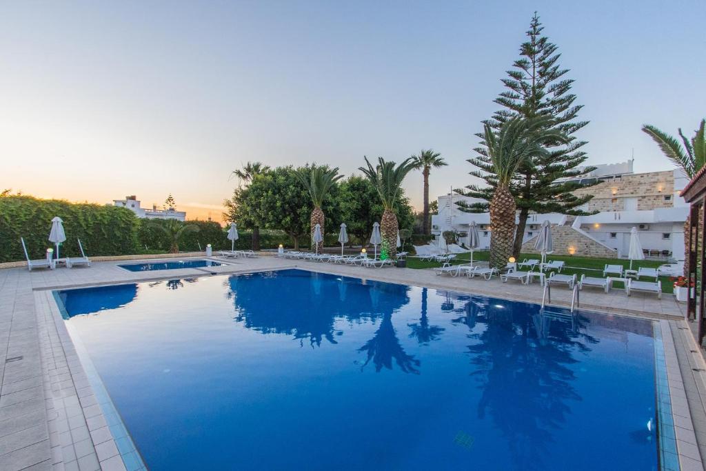 uma grande piscina com água azul num resort em Abella Hotel em Agia Marina Nea Kydonias