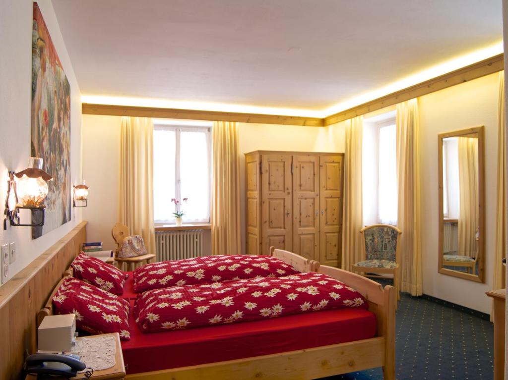 Postel nebo postele na pokoji v ubytování Poschiavo Suisse Hotel & Traditional Fondue Stube